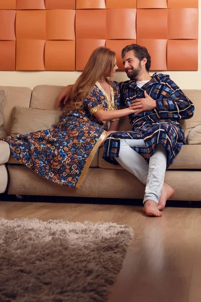 Picture of women and men in home clothes hugging on sofa — Stock Photo, Image