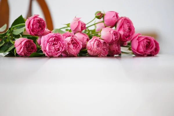 Imagen de flores rosadas sobre mesa de madera blanca — Foto de Stock