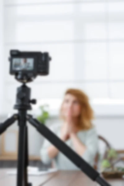 Defocused picture of florist girl sitting at table with florarium — Stock Photo, Image