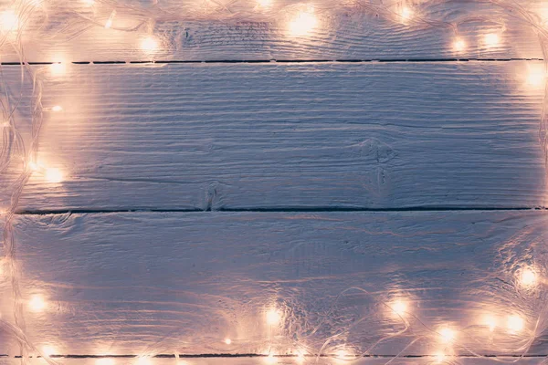Picture of Christmas wooden gray table with burning garland on perimeter. — Stock Photo, Image