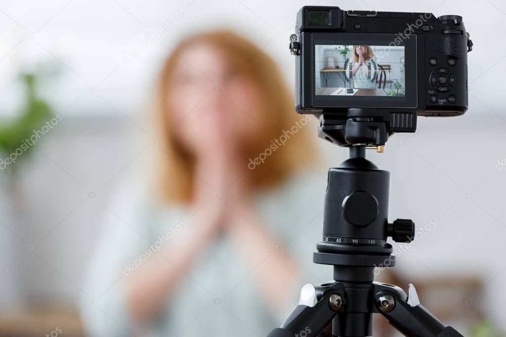 Blurred picture of woman blogger at table with florarium.