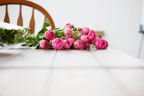 Foto de ramo de peonías rosadas sobre mesa de madera blanca — Foto de Stock