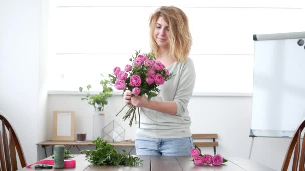 Жінка-флорист робить квітковий букет — стокове відео