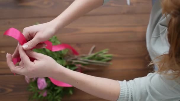 トップ ビューの女性の花屋 (フラワー ショップ)、peone、結婚式のためのばら色の花の組成の美しい花束を作る — ストック動画