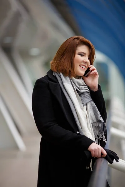 전화 통화 하는 검은 코트에 여자의 이미지 — 스톡 사진