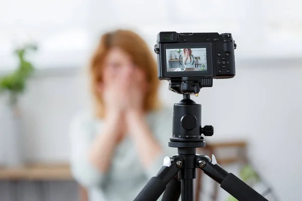 Intreepupil beeld van bloemist vrouw die betrekking hebben op gezicht met handen aan tafel met florarium. — Stockfoto