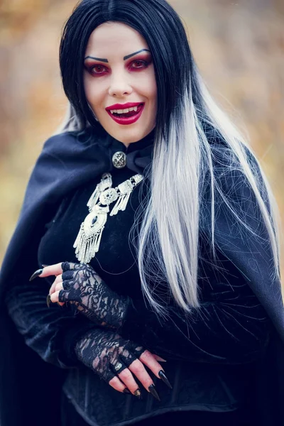 Foto de mulher vampira lambendo com cabelos longos, olhos vermelhos — Fotografia de Stock