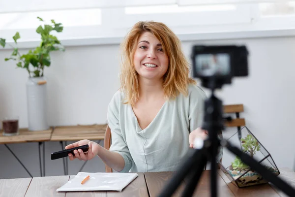 Imagen de una bloguera feliz en la mesa con florario . — Foto de Stock