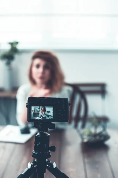 Intreepupil beeld van bloemist vrouw zittend op tafel met succulente in glazen pot. — Stockfoto