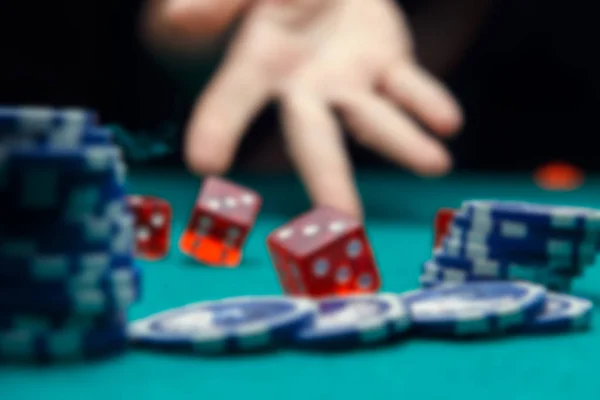 Defocused photo of dice, chips, palm in casino — Stock Photo, Image