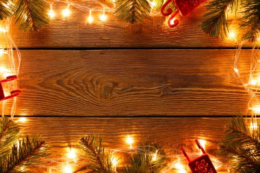 Garland çevresindeki, Ladin, dalları yanma ile ahşap yüzey görüntüsünü oyuncaklar hissettim.