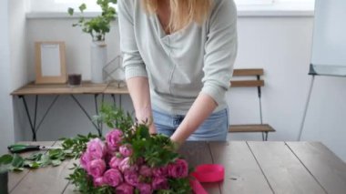 Çiçekçi bir buket çiçek satışı için hazırlar.