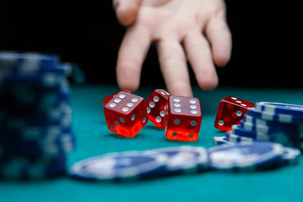 Picture of man throwing dice on table with chips in casino — Stock Photo, Image