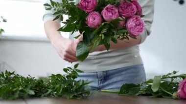 Çiçekçi bir buket çiçek satışı için hazırlar.