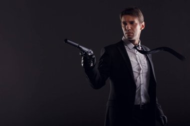 Deri eldiven siyah arka plan üzerine izole silahla adam portresi.