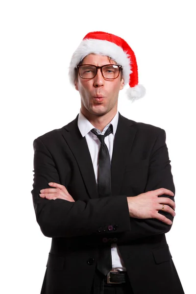 Bild eines pfeifenden Mannes im Business-Anzug, Brille, Weihnachtsmannmütze, mit verschränkten Armen — Stockfoto