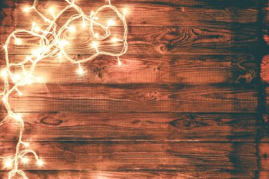 Garland solda parlayan ile koyu kahverengi ahşap arka plan