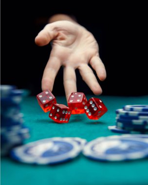 Adam masada kırmızı zar atma görüntüsünü casino fişleri