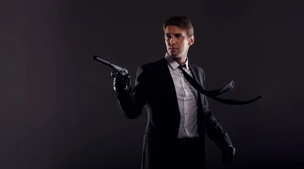 Image of man with developing tie in leather gloves with gun — Stock Photo, Image