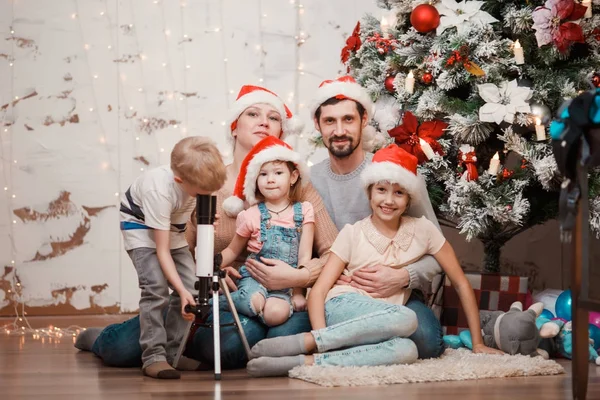 Nieuwe jaar beeld van ouders, twee dochters en zoon met telescoop — Stockfoto