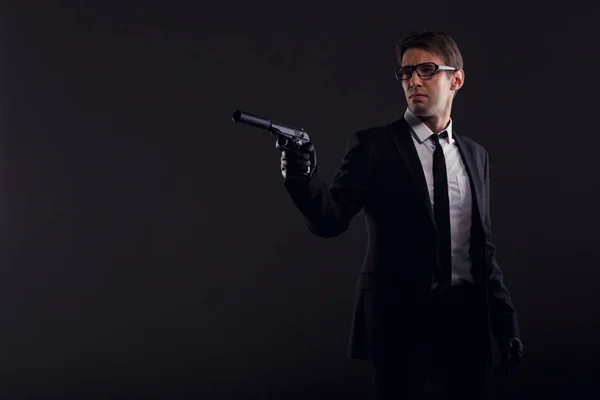 Az ember a szemüveg és a bőr kesztyű fegyvert fénykép — Stock Fotó