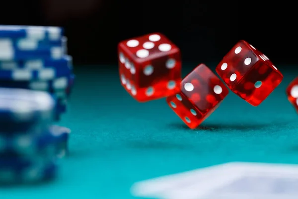 Foto kostky, žetony v kasinu na zeleném stole — Stock fotografie
