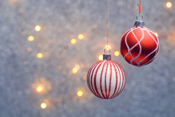 Bild von roten Weihnachtskugeln mit Muster auf grauem Hintergrund mit brennenden Lichtern. — Stockfoto
