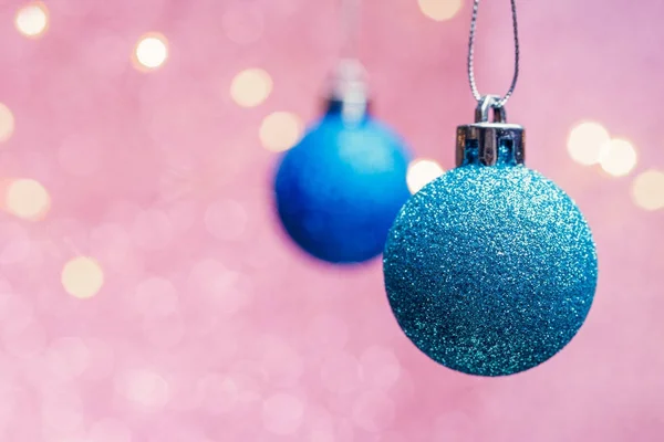 Image of two Christmas blue balls on pink background with spots. — Stock Photo, Image