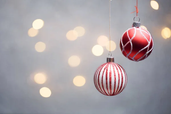 Foto de bolas rojas de Navidad sobre fondo gris con luces calientes . — Foto de Stock