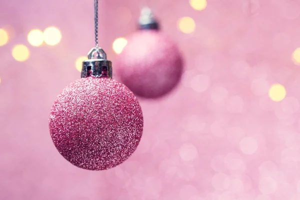 Afbeelding van twee roze kerstballen op roze achtergrond met stippen. — Stockfoto