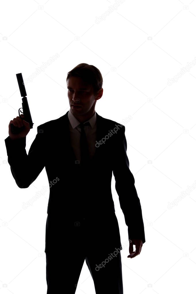 Silhouette of man in business suit with gun at hand isolated on white background