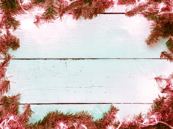 Çam ağacı ve ampul ahşap tahta üzerinde Noel arka plan — Stok fotoğraf