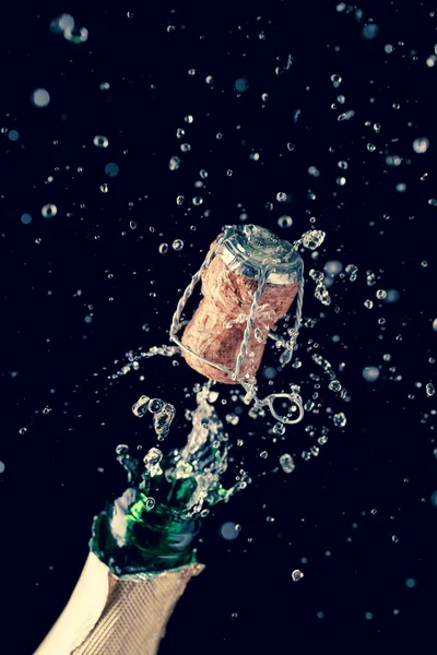 Opening bottle of champagne on empty black background — Stock Photo, Image