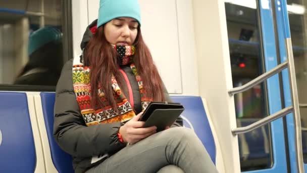 Νεαρή γυναίκα ανάγνωσης e-book στο μετρό στο σταθμό στο μετρό — Αρχείο Βίντεο