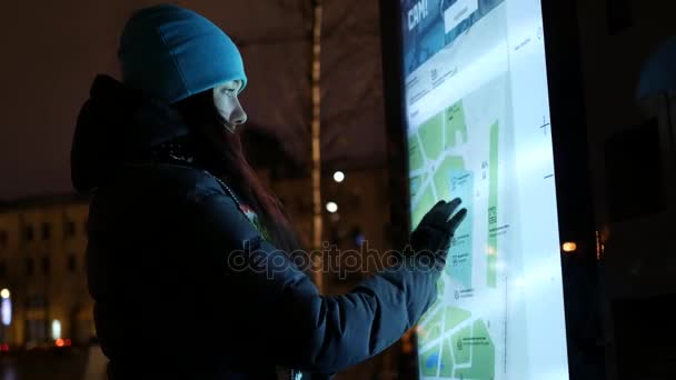 Žena pomocí panelu ulice informace na ulici v noci. — Stock video