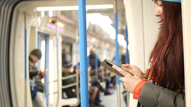 Mladá žena číst e knihy ve vlaku metra na metro — Stock video