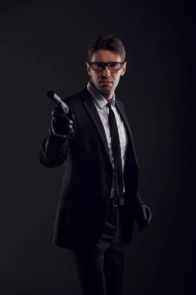 Picture of gangster man wearing glasses and leather gloves with gun — Stock Photo, Image