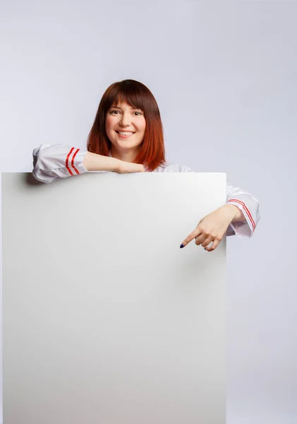 Photo of cook girl in white lab coat with empty sheet for inscription — Stock Photo, Image