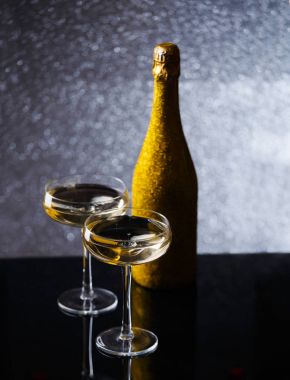 Şenlikli şişe şampanya altın sarmalayıcı iki Şarap kadehi ile fotoğrafı