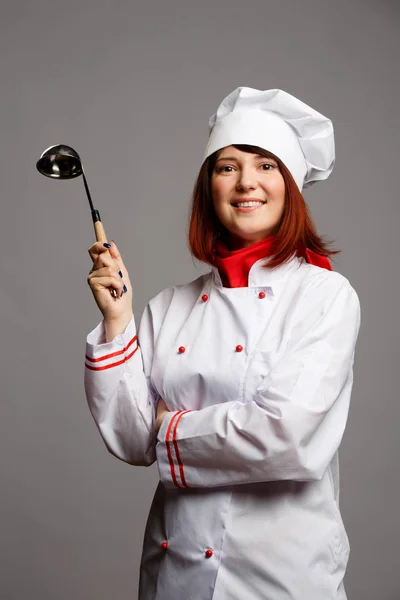 Imagem de mulher cozinhar em roupão branco e chapéu com concha na mão — Fotografia de Stock