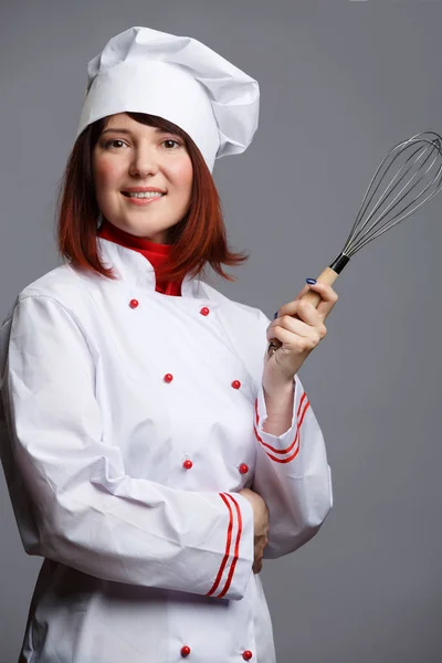 白色长袍和帽子的女厨师的照片在她的手扫 — 图库照片