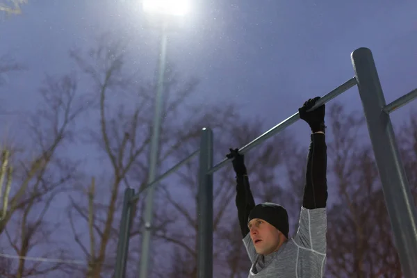 Foto des Athleten, der abends an der Stange zieht — Stockfoto