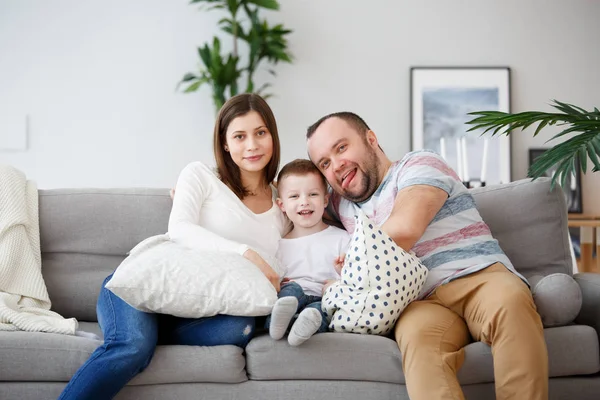 Photo of happy parents with son on gray sofa — Stock Photo, Image