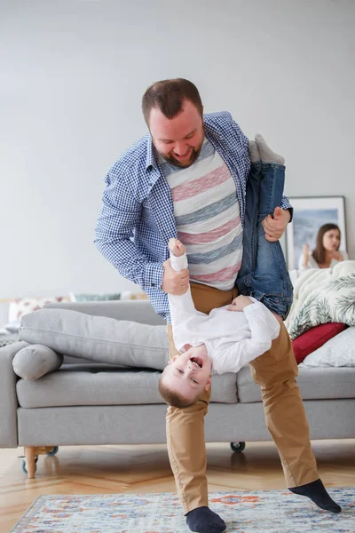 Family picture of man holding son in apartment