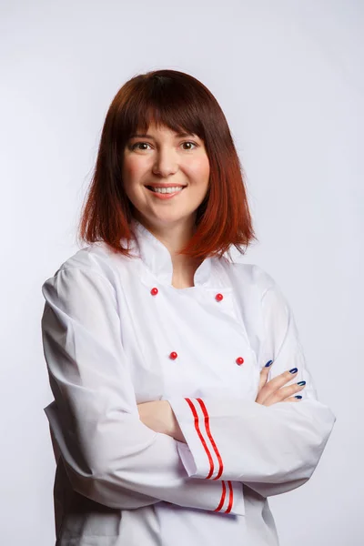 Photo of female chef in white robe on empty background — Stock Photo, Image