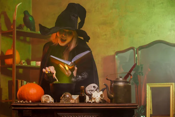 Imagen de bruja con libro de hechizos en cuarto oscuro — Foto de Stock