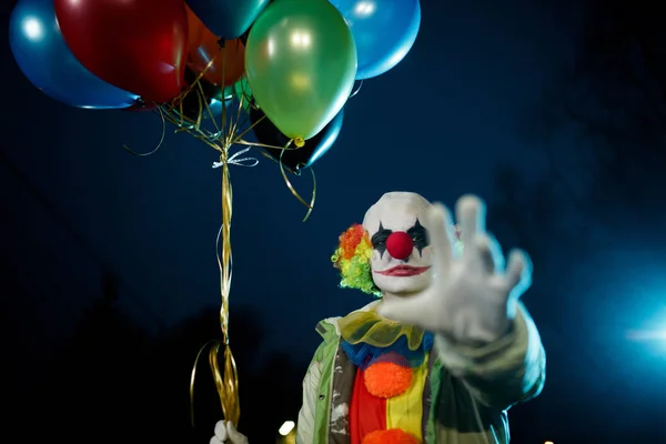 Bild av clown med bollar i händerna på natten på gatan — Stockfoto