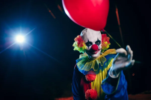 Foto av clown med röd ballong på bakgrund av brinnande lykta — Stockfoto