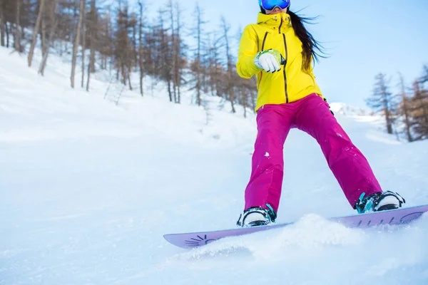 Foto de atleta niña en casco y máscara snowboard desde la ladera nevada con árboles —  Fotos de Stock