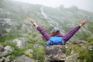 Kız sırt çantası ile eller yukarı ile arka üzerinden görüntü